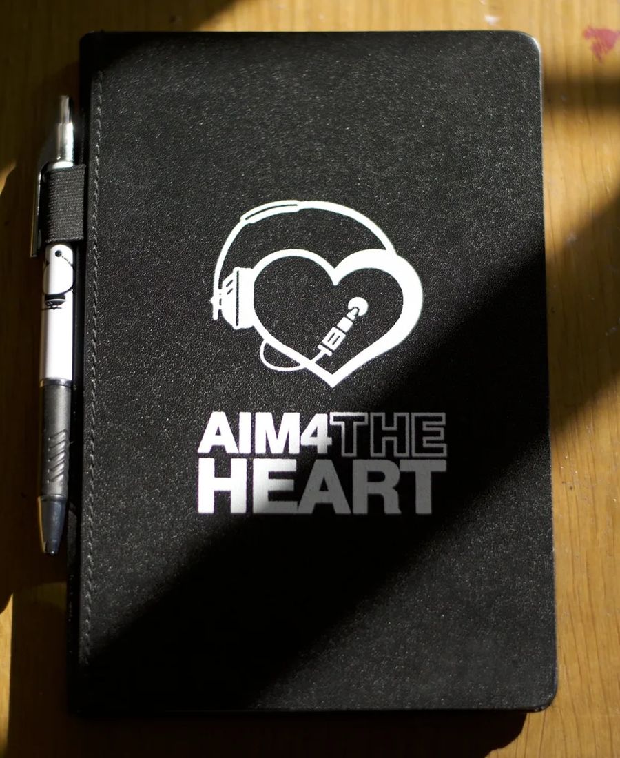 An AIM 4 The Heart notebook and pen from a workshop